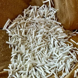 Natural white dentalium shells in bulk on burlap fabric for jewelry making and crafts
